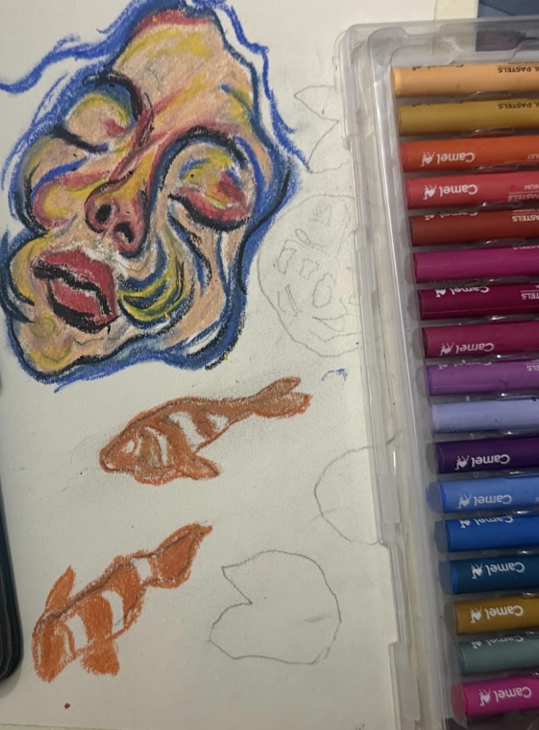 Yellow worked into the face, dark outlines around the features, and the first two koi colored orange