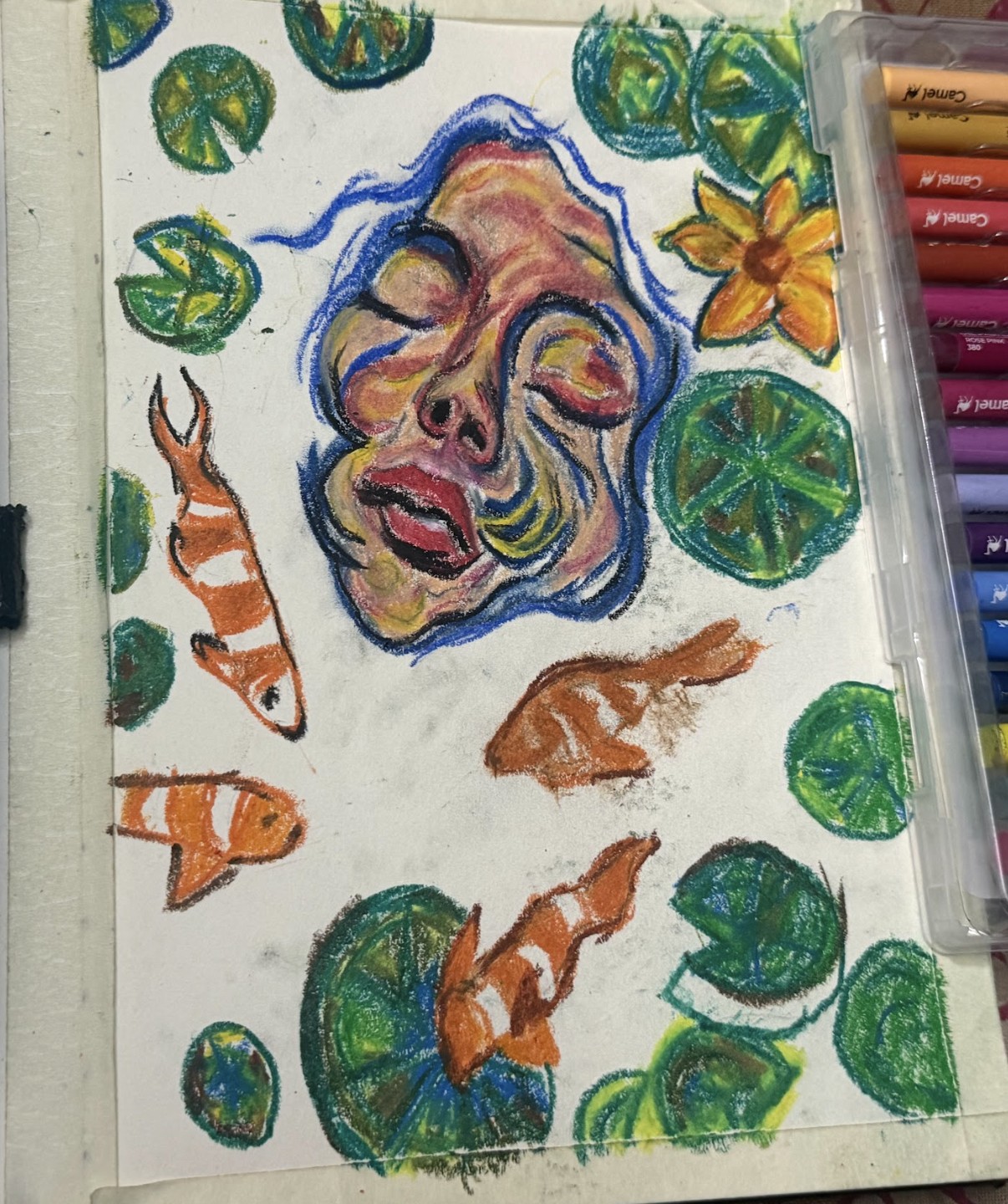 Green lily pads, a yellow flower and more orange koi added around the face on the white page